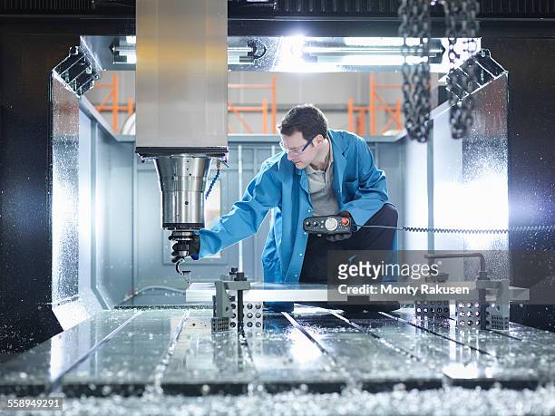 worker in large cnc machine in plastics factory - cnc maschine stock pictures, royalty-free photos & images