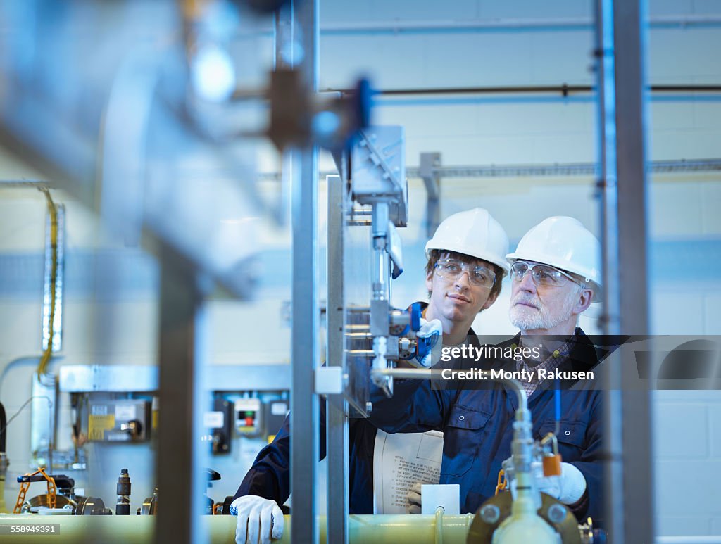 Senior and apprentice engineers working in power station