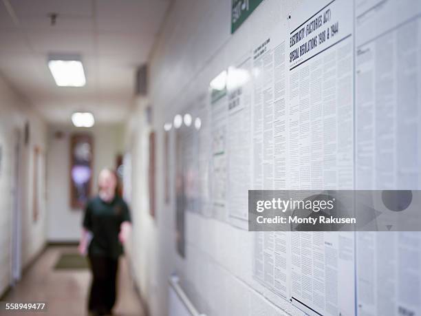 female worker in corridor of factory - bulletin board stock-fotos und bilder