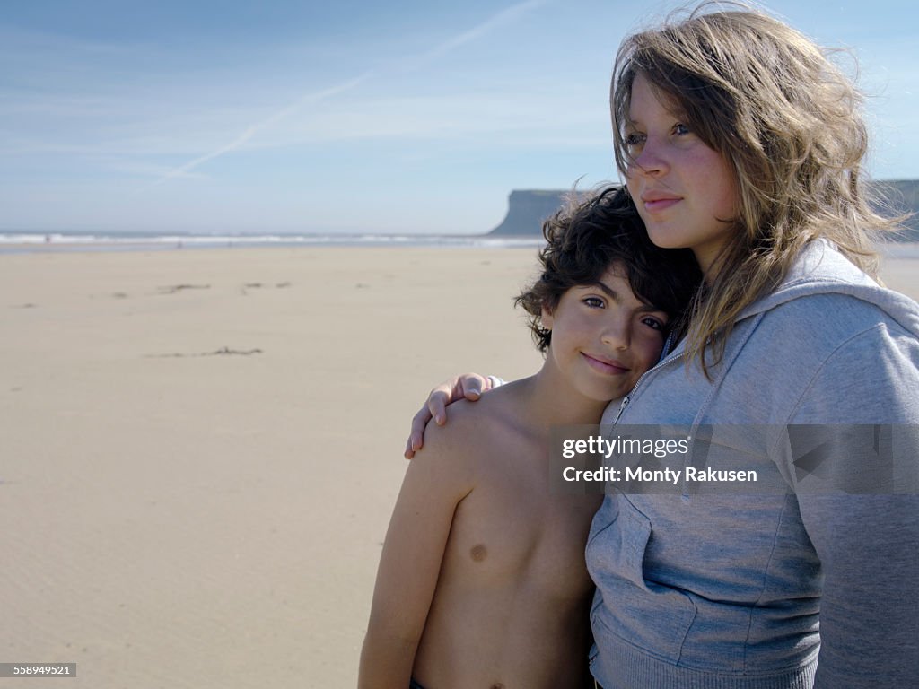 Brother and sister together on beach, portrait