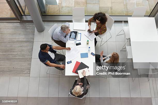 overhead view of business team having meeting at conference table - concept updates stockfoto's en -beelden