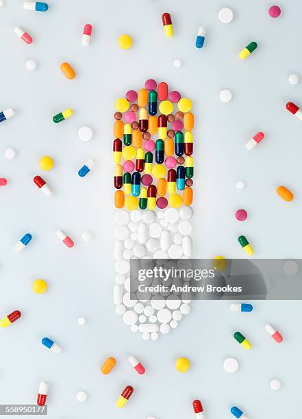 medical pills and tablets in shape of drug capsule and scattered - pills colorful stock pictures, royalty-free photos & images