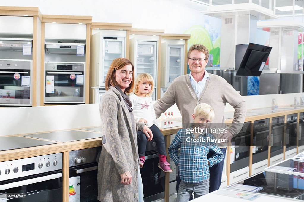 Portrait of family with two children browsing hobs in electronics store