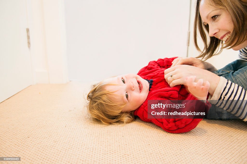 Mother tickling son