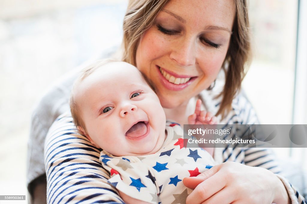 Mother tickling baby daughter