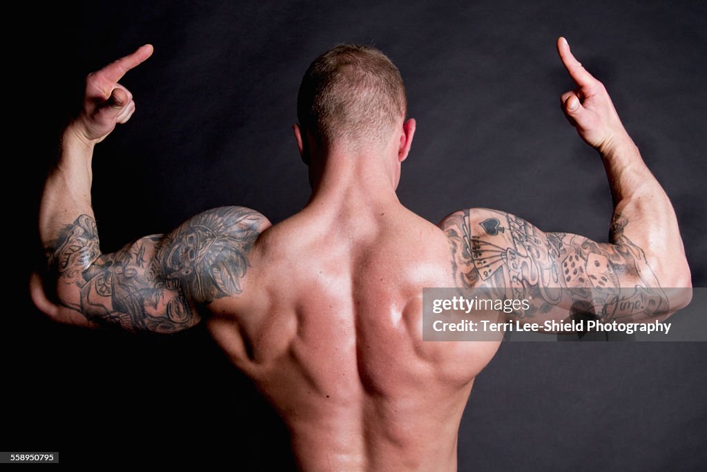Young man showing rear double biceps
