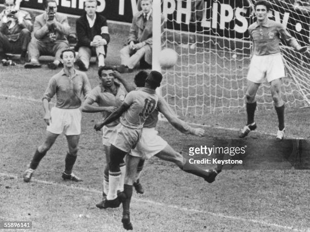 Brazilian forwards Vava and Pele enter a melee in front of the French goal during the the World Cup semi-final at the Rasunda Stadion in Solna,...