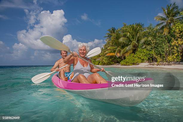 senior couple in canoe, maldives - maldives boat stock pictures, royalty-free photos & images