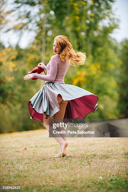 young woman dancing in park revealing bare buttocks - bare bottom women - fotografias e filmes do acervo