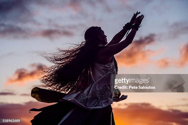 silhouetted woman hula dancing wearing traditional costume at dusk, maui, hawaii, usa - hula dancing stock pictures, royalty-free photos & images
