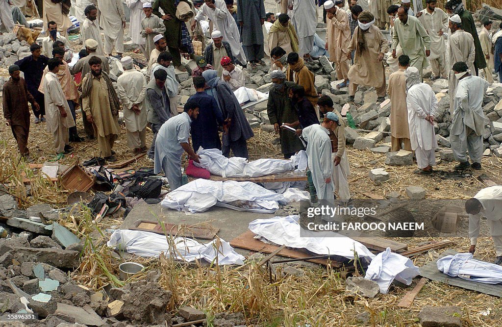 Pakistani residents line up the bodies o