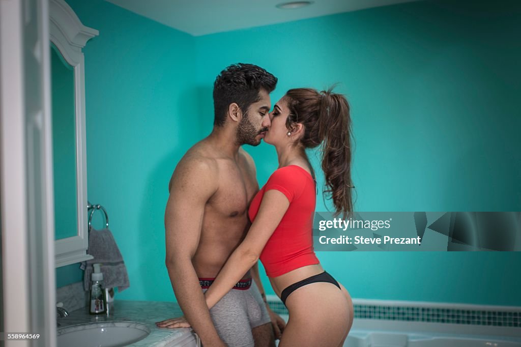 Portrait of young couple kissing in bathroom