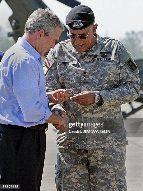New Orleans, UNITED STATES: US President George W. Bush recieves a command coin from Lt. General Russell Honore at the US Naval Air Station, Joint...