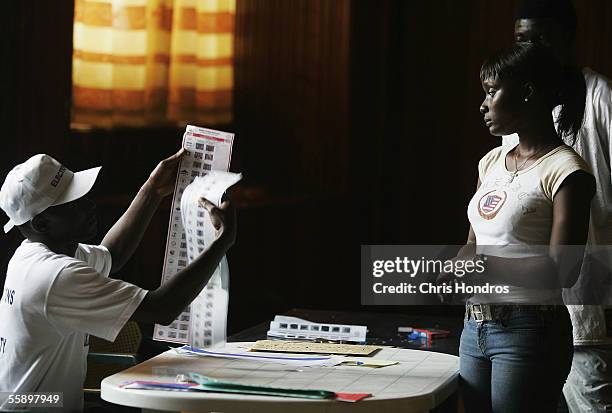 Liberian poll worker hands a ballot to a voter October 11, 2005 in Monrovia, Liberia. Liberia, beset by 13 years of savage civil war and two years of...