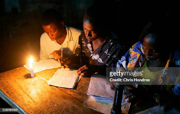 Electoral observers from the individual political parties take notes by candlelight after the polls closed October 11, 2005 in Monrovia, Liberia....