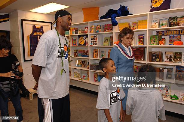 Hawaii Governor Linda Lingle and Kobe Bryant of the Los Angeles Lakers look over books with children during the dedication of a Lakers reading room...