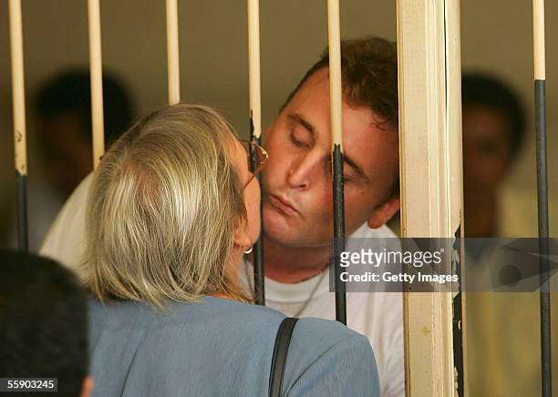 Australian Martin Stephens kisses his mother, Michelle, through the bars of the holding cell at the Denpasar District Court for the beginning of his...