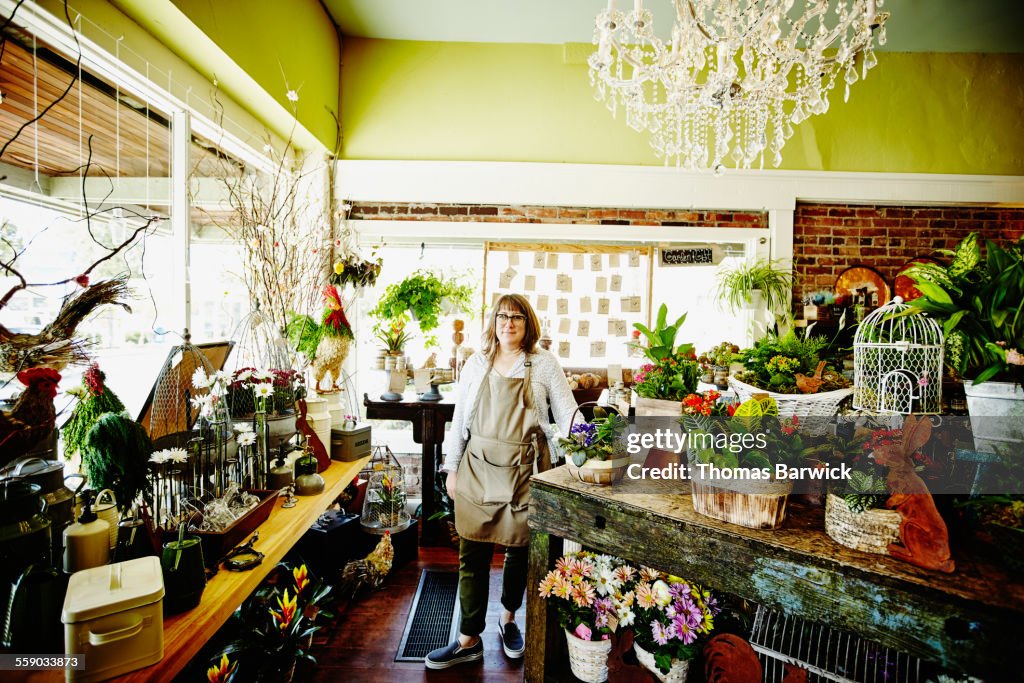 Smiling floral shop owner standing in flower shop