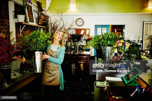 florist carrying bucket filled with flowers - florista fotografías e imágenes de stock