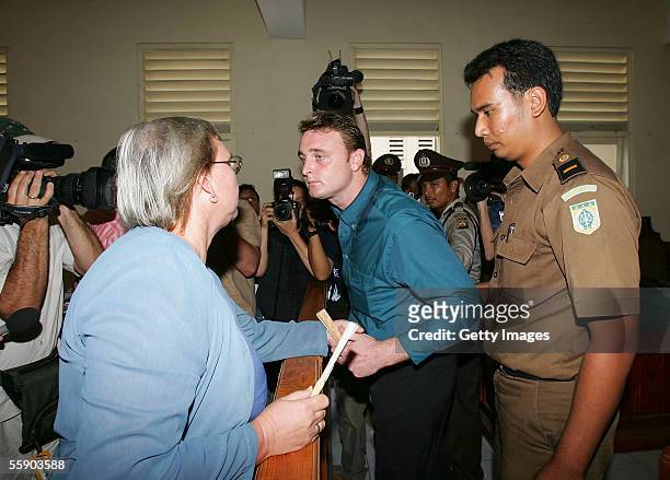 Australian Martin Stephens reaches out to his mother, Michelle, as he is escorted to his appearance in Denpasar District Court at the beginning of...