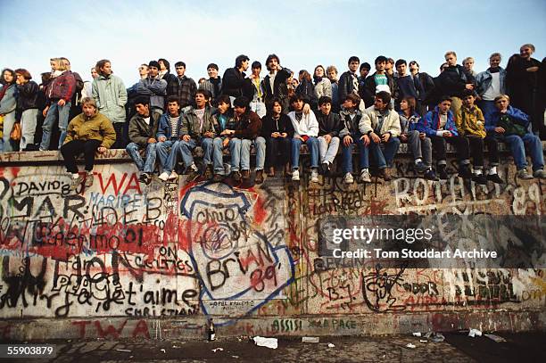 Jublilant crowds celebrate freedom on top of the Berlin Wall on the morning of November 10th 1989. They are on a section of the wall near the...