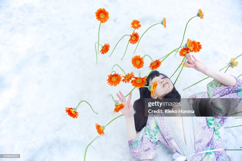 Woman and flowers bloom on top of the snow