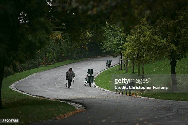 Man braves the autumn rain as he walks his dog in a park on October 10, 2005 in Glasgow, Scotland. Seasonal affective disorder , or winter...