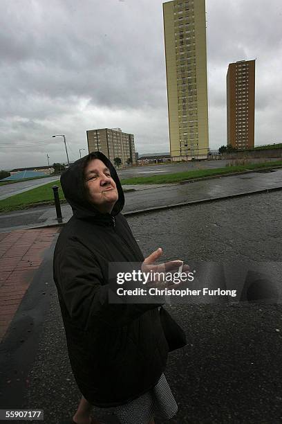 Woman puffs on her cigarette and enjoys a joke as she makes her way to the shops in the dreary weather on October 10, 2005 in Glasgow, Scotland. Many...