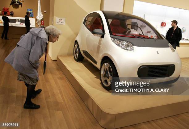 New York, UNITED STATES: A museum patron looks at the Nido by Pininfarina, a car with a spring inside to reduce crash impact, on display during the...
