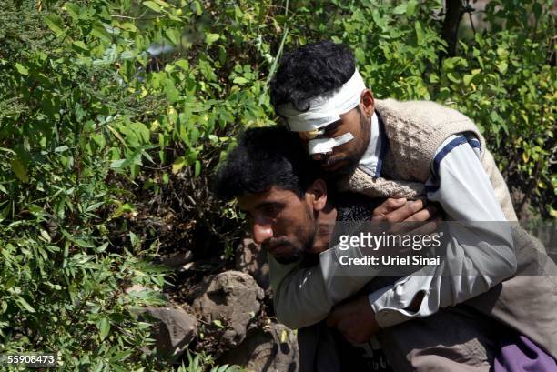Kashmiri villager, Rafik Bagi, is carried by his brother Rashid up to his home from the hospital October 12, 2005 in the mountain village of Kamel...