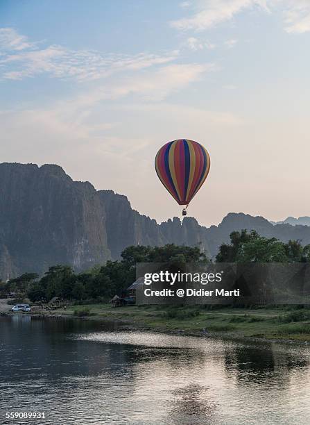 hot air balloon over vang vieng - vang vieng balloon stock pictures, royalty-free photos & images