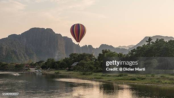 hot air balloon over vang vieng - vang vieng balloon stock pictures, royalty-free photos & images