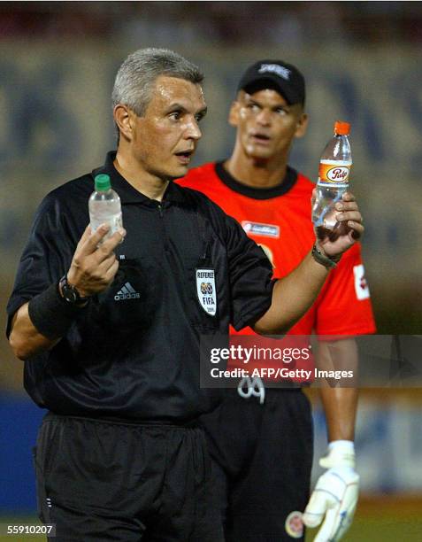 Marcio Resende arbitro brasileno del partido Paraguay-Colombia, muestra botellas de refresco arrojadas por el publico durante el partido donde la...