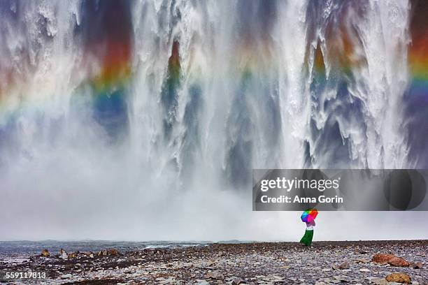 tourist with rainbow umbrella at skogafoss iceland - majestic waterfall stock pictures, royalty-free photos & images