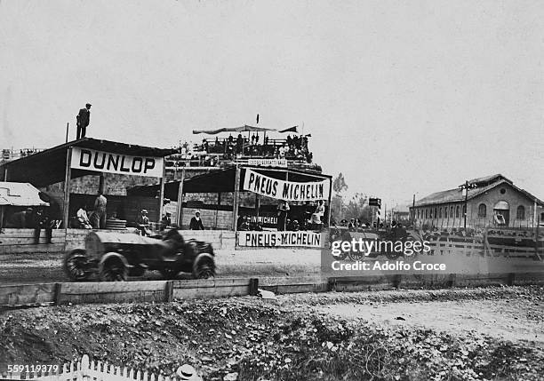 Alessandro Cagno of Italy and his riding mechanic drives the ITALA past the watching spectators and tyre pits during the I Coppa Velocita di Brescia...