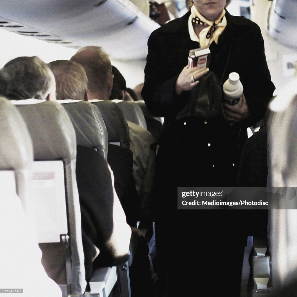 Female airline stewardess serving passengers