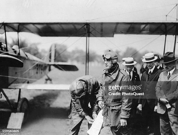 Major RH Fleet attaches an aerial map to the leg of Lt George L Boyle who flew the first mail plane and inaugurated airmail service, 1918.