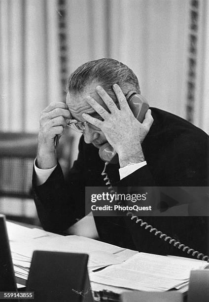 American President Lyndon Johnson talks on the telephone at his desk in the White House, Washington DC, 1964.