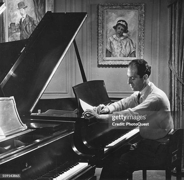 American composer George Gershwin works on a score at the piano in his 72nd Street apartment, New York, New York, 1934.