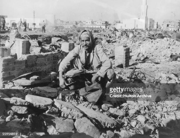 An elderly man searches through the ruins of his home in Port Said during the Suez Crisis, 12th November 1956.