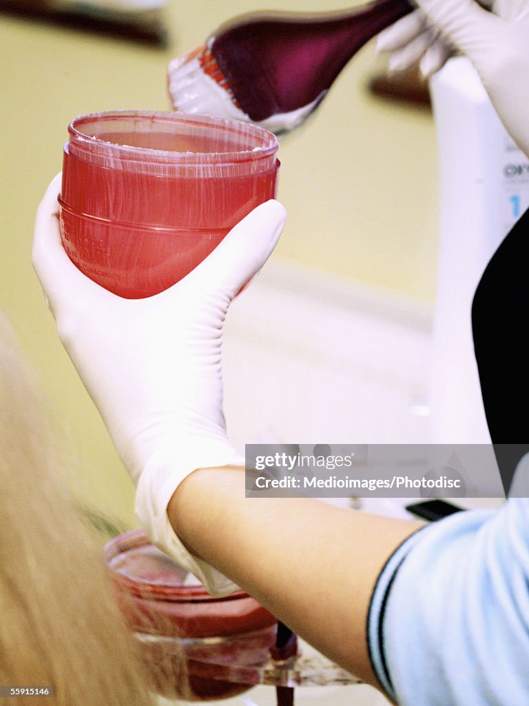 Close-up of a woman's hand mixing hair dye in a container