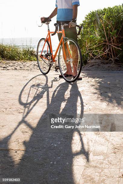 senior man with his bike and shadow. - norman elder stock-fotos und bilder