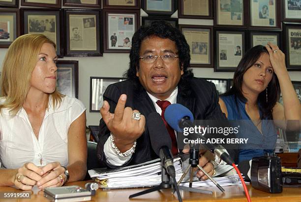 Schapelle Corby's lawyer Hotman Paris Hutapea talks to journalists as Scapelle's sister Mercedes and a lawyers staff Sophia latjuba listen to during...