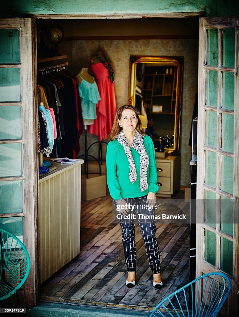 Smiling female business owner standing in boutique