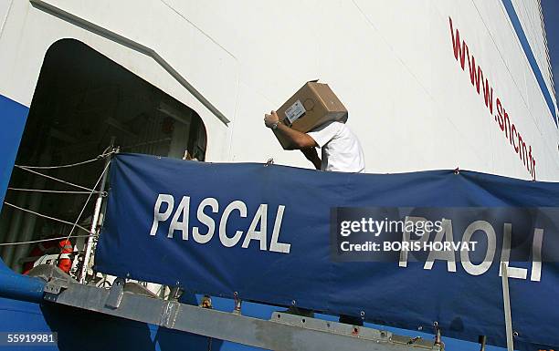 An employee of the port of Marseille carries a box on board of the cargo-passenger ship Pascal Paoli, 14 October 2005 in Marseille, southern France....