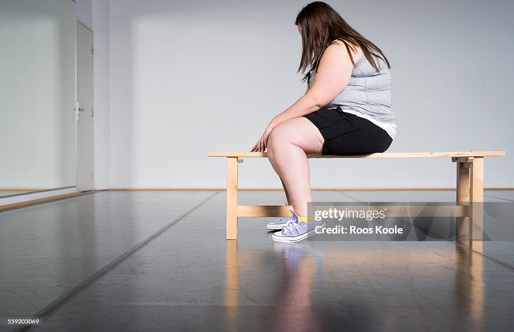 Teenage overweight girl in gym