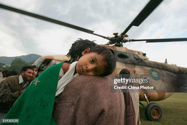 An injured young boy is carried to a rescue helicopter on October 13, 2005 in Muzaffarabad, capital city of Pakistan-controlled Kashmir. Aid from 30...