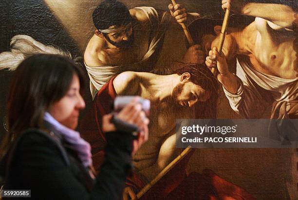 Woman looks at Italian painter Caravaggio's "Coronation of thorn" in Palazzo Reale during an exhibition called Caravaggio and Europe in Milan, 14...