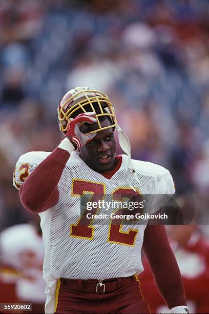 Defensive lineman Dexter Manley of the Washington Redskins removes his helmet during a game against the Philadelphia Eagles at Veterans Stadium on...