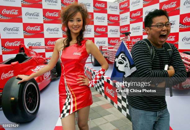 An audience member poses for pictures with a model during the Chinese F1 Grand Prix at the Shanghai International Circuit on October 14, 2005 in...